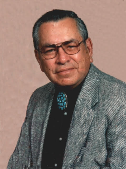 Portrait of Raul Harold Vigil, Sr. wearing glasses, a jacket, and a turquoise bolo tie